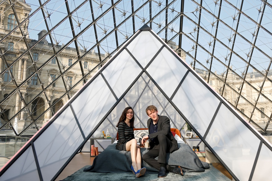 Daniela and Adam from Newcastle, U.K., winners of a contest by Airbnb, pose on a bed under the glass Pyramid at the Louvre museum in Paris, France, April 30, 2019. Airbnb and the Louvre museum offered the chance to spend a night in the Louvre museum, an aperitif in front of the painting "Mona Lisa" (La Joconde) by Leonardo Da Vinci, a dinner in front of the Venus de Milo statue during a private visit and finally sleep in their own little mini pyramid under the glass Pyramid. REUTERS/Charles Platiau