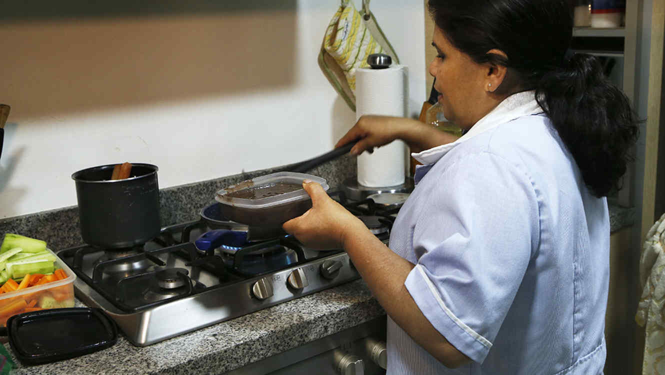 In this Dec. 14, 2018 photo, domestic worker Rocio Campos, 55, prepares lunch for her employer, in Mexico City. The Supreme Court ruled on Dec. 5 that Mexico's more than 2 million domestic workers should be enrolled in the social security system, offering them greater rights as well as access to the public health system and free, government-run daycare. (AP Photo/Marco Ugarte)