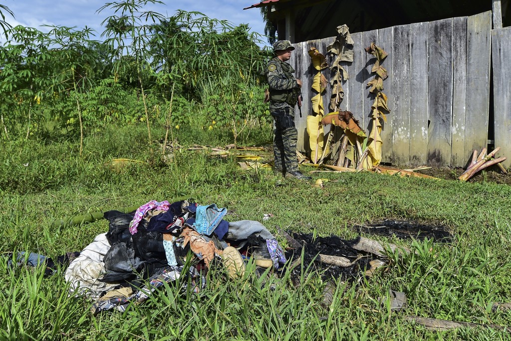A member of Panama's Special Police Forces stands guard near clothes outside an improvised church where a pregnant woman, five of her children and a sixth minor were killed in a religious sacrifice, in Altos del Terron, Ngabe Bugle region, Panama, on January 20, 2020. - A judge from Panama sentenced on Friday preventive prison for nine alleged members of a religious sect accused of sacrificing and killing six minors and a pregnant woman, whose remains were found in a mass grave. (Photo by Luis ACOSTA / AFP)