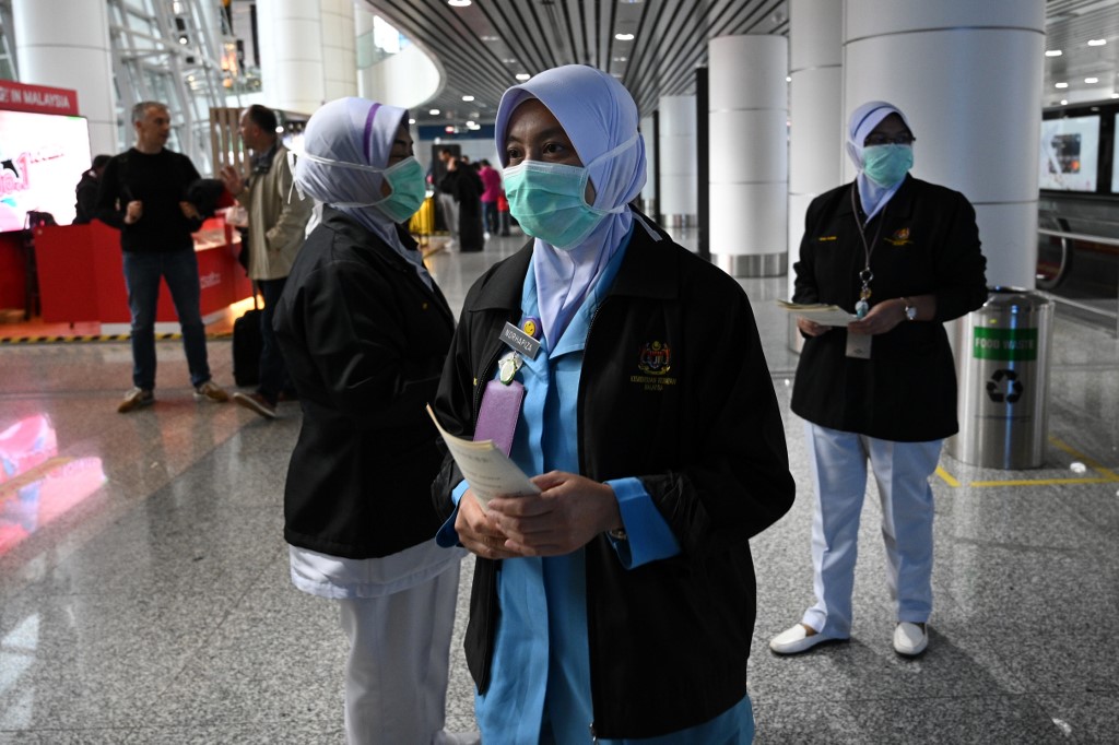 Malaysian health officers are deployed at Kuala Lumpur International Airport in Sepang on January 21, 2020 as authorities increased measure against coronavirus. - China has confirmed human-to-human transmission in the outbreak of a new SARS-like virus as the number of cases soared and authorities January 21 said a fourth person had died, as the World Health Organization said it would consider declaring an international public health emergency over the outbreak. (Photo by MOHD RASFAN / AFP)