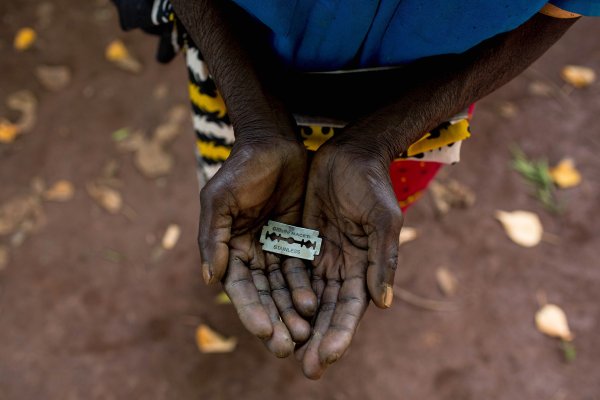 A woman shows the razor blade that she uses to cut girls' genitals in Mombasa, Kenya, June 25, 2015. Ivan Lieman—Barcroft Media