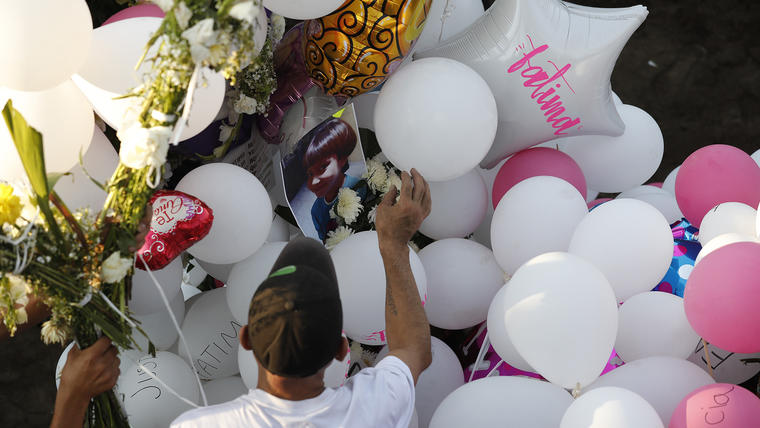 Family members place balloons and flower arrangements on the grave of 7-year-old murder victim Fatima in Mexico City, Tuesday, Feb. 18, 2020. Fatima's body was found wrapped in a bag and abandoned in a rural area on Saturday. Five people have been questioned in the case, and video footage of her abduction exists. (AP Photo/Marco Ugarte)
